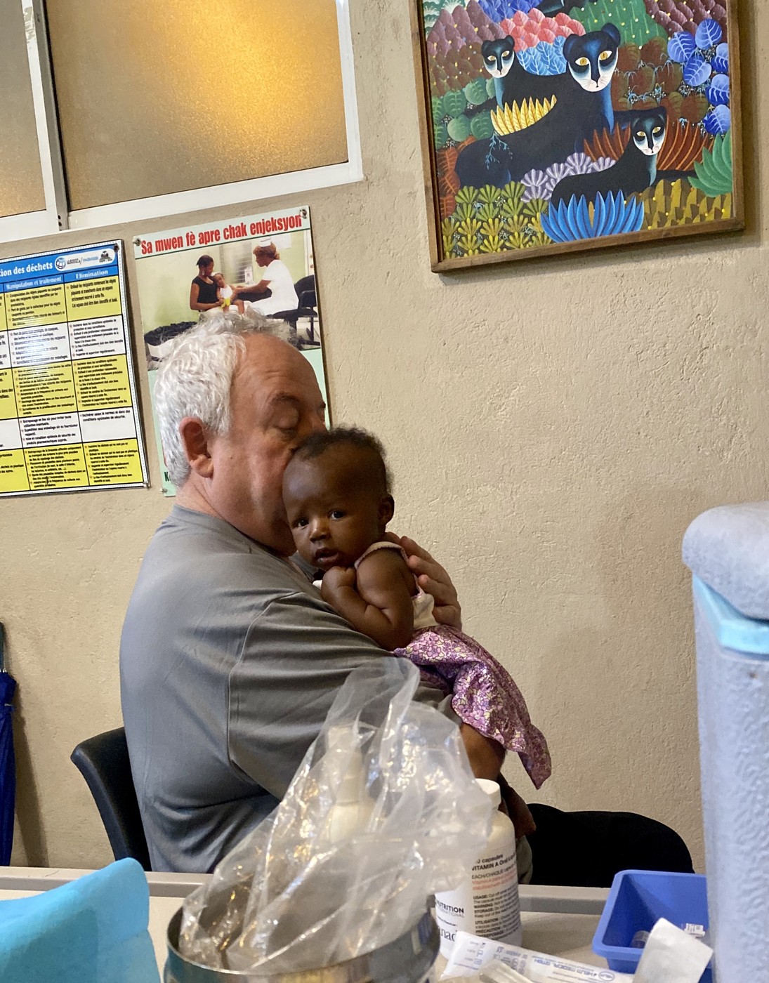 Randy Moore holding an infant at the clinic in Cap-Haïtien