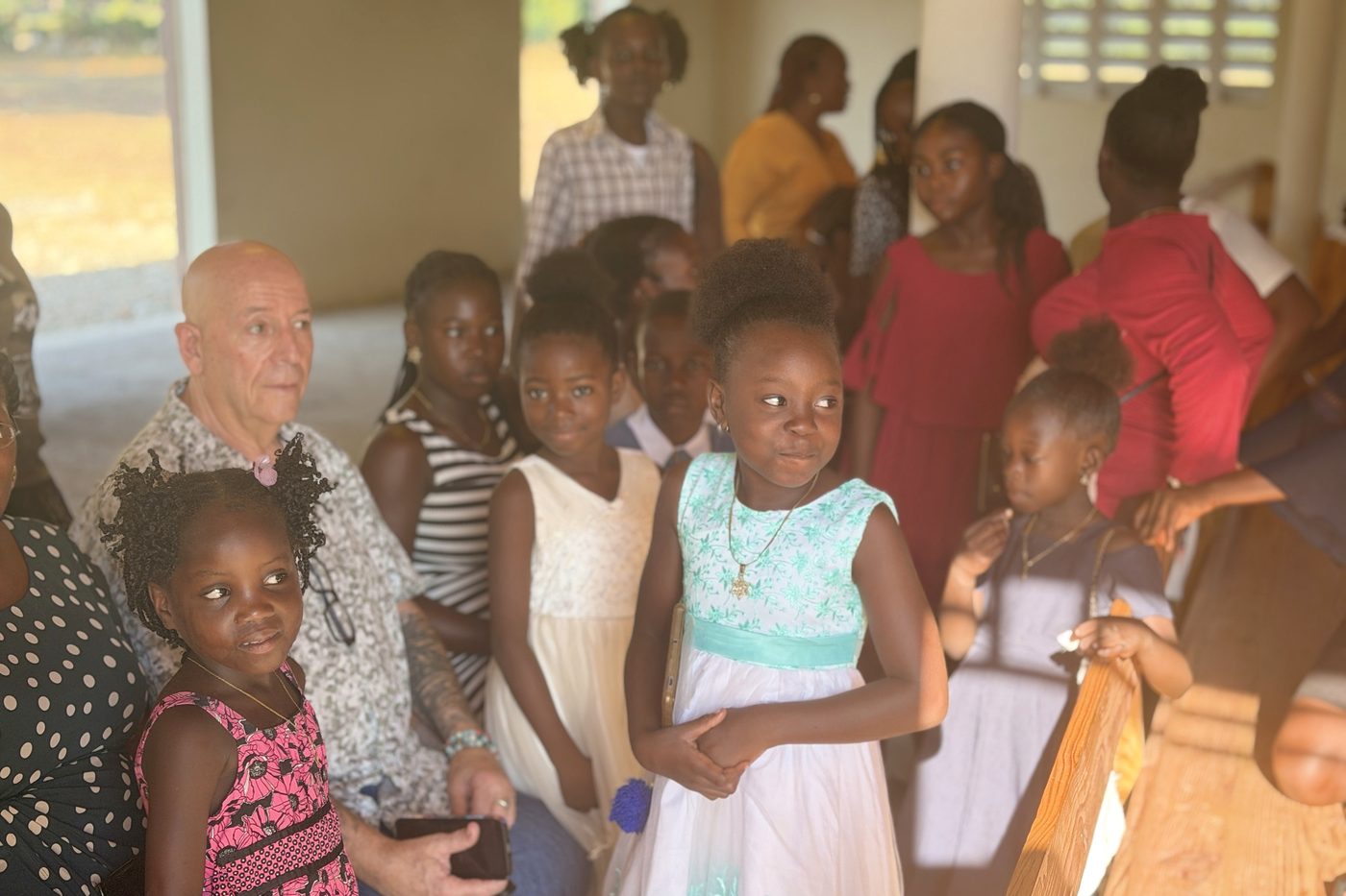 Randy Moore sits among children and parents gathered at a school in Cap-Haïtien.