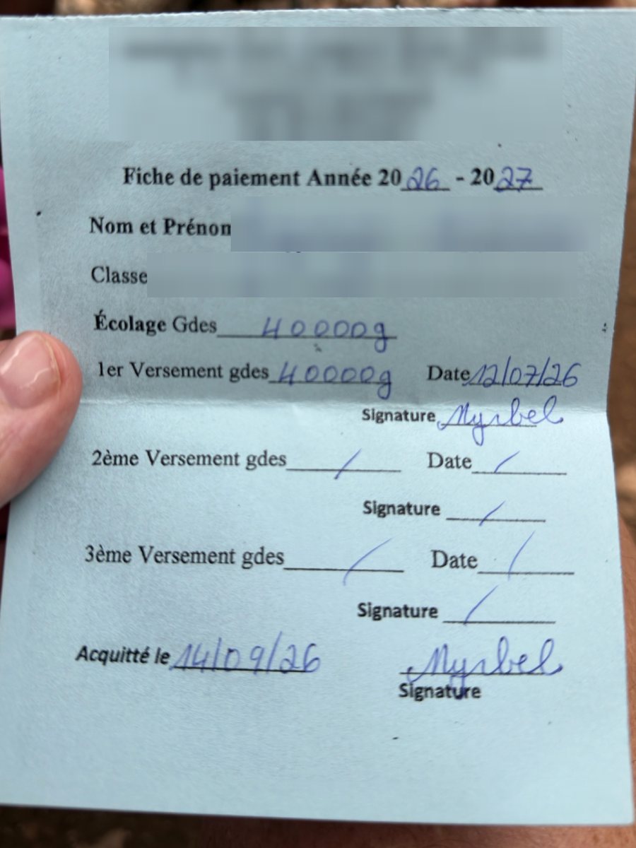 A school payment slip for the 2026-27 year marked paid in full and signed by the school, with the student's name, class and the school's details blurred.