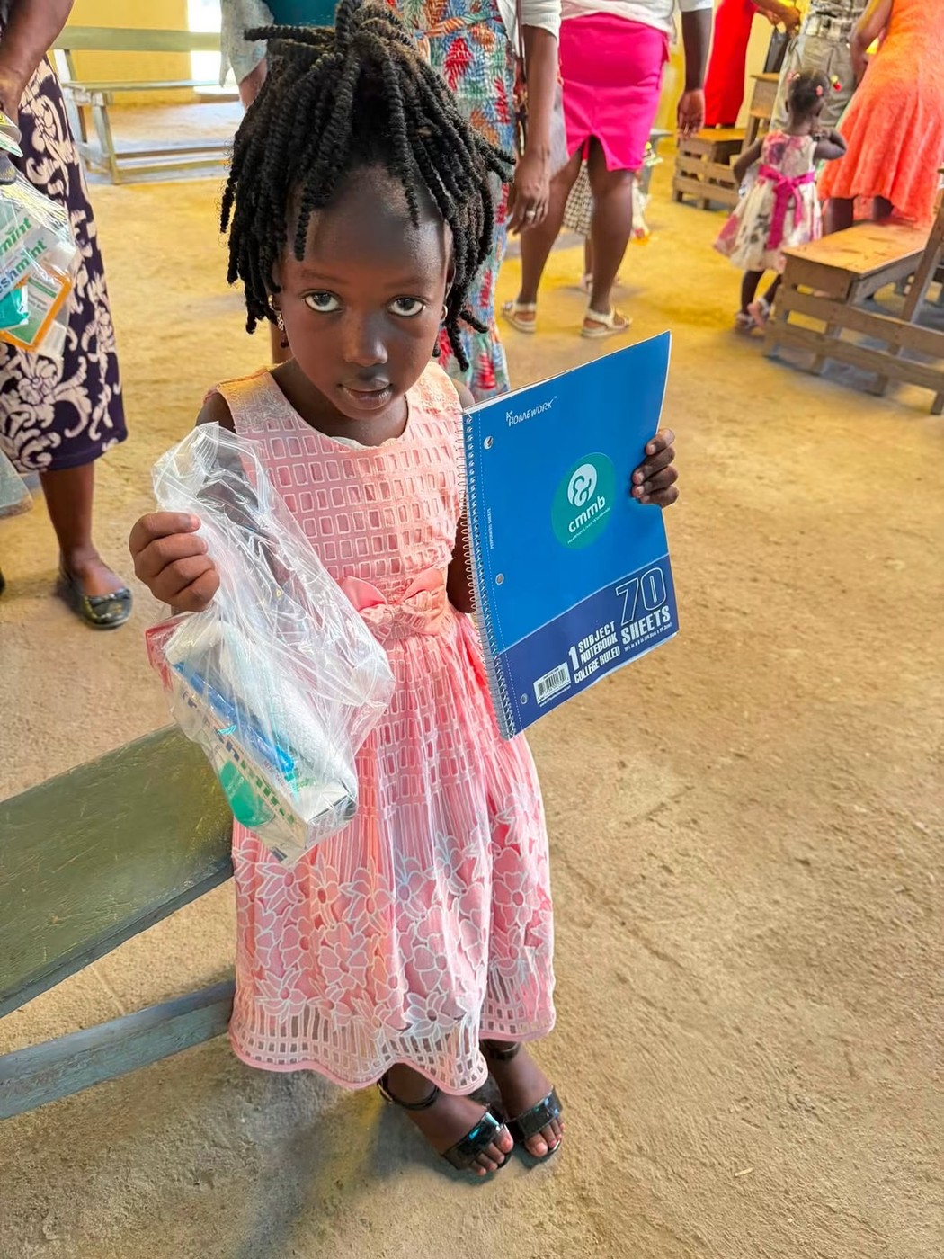 A student in Cap-Haïtien with her new notebook and school supplies